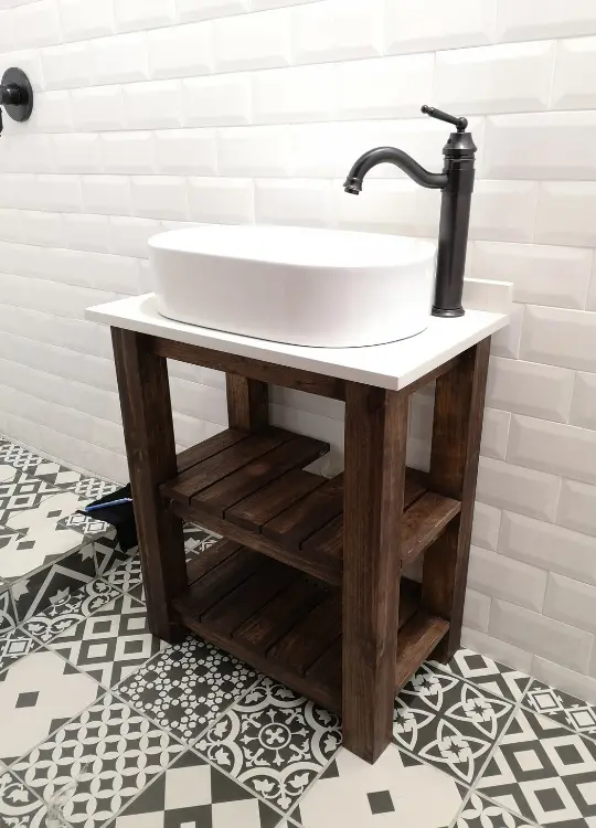 White bathroom sink on a wooden shelving unit