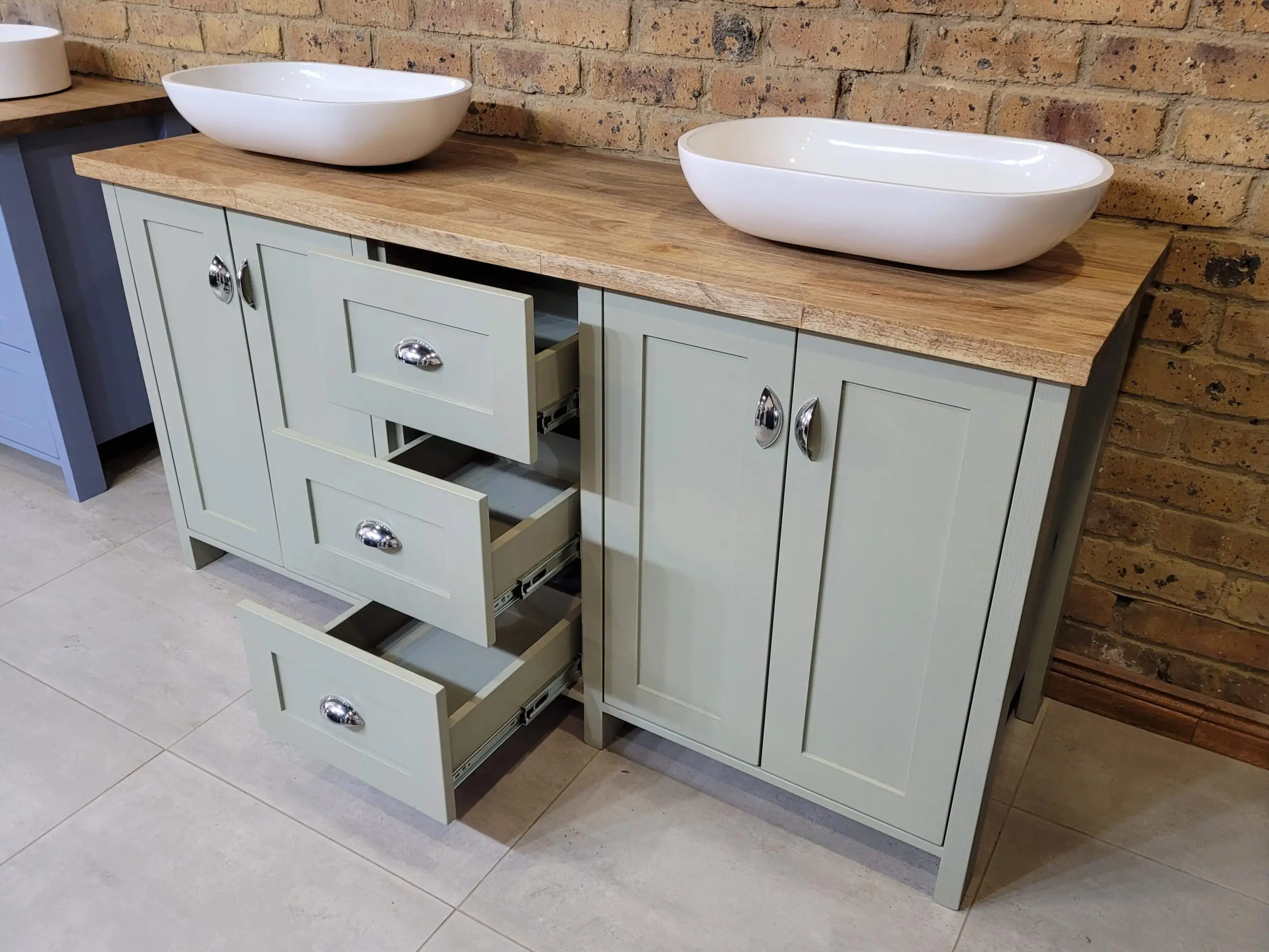 A green double basin bathroom unit with drarwers