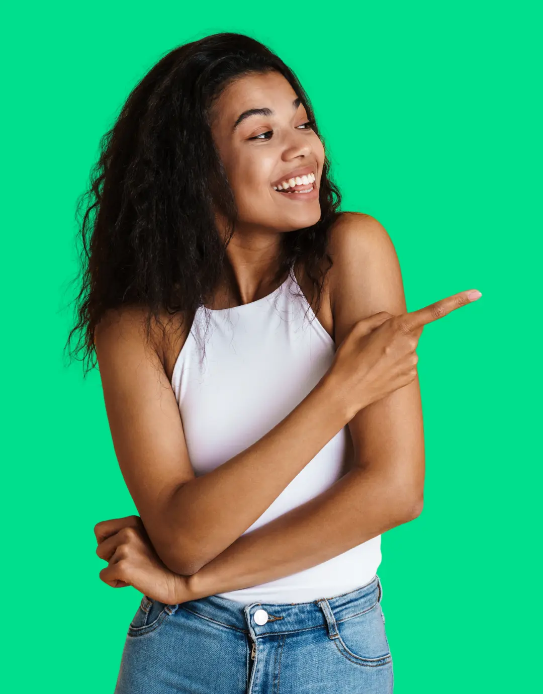 Woman in white top pointing right, green screen behind her