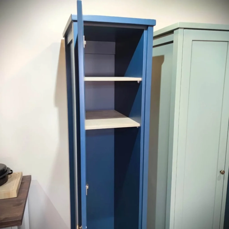 An open blue broom cabinet with shelving at the top