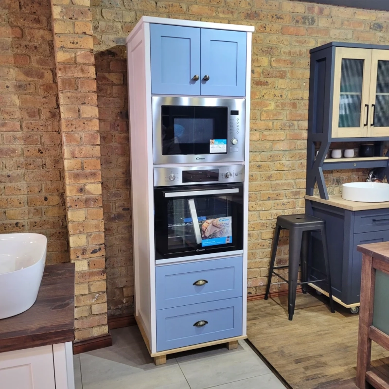 A blue eye level oven unit in a show room
