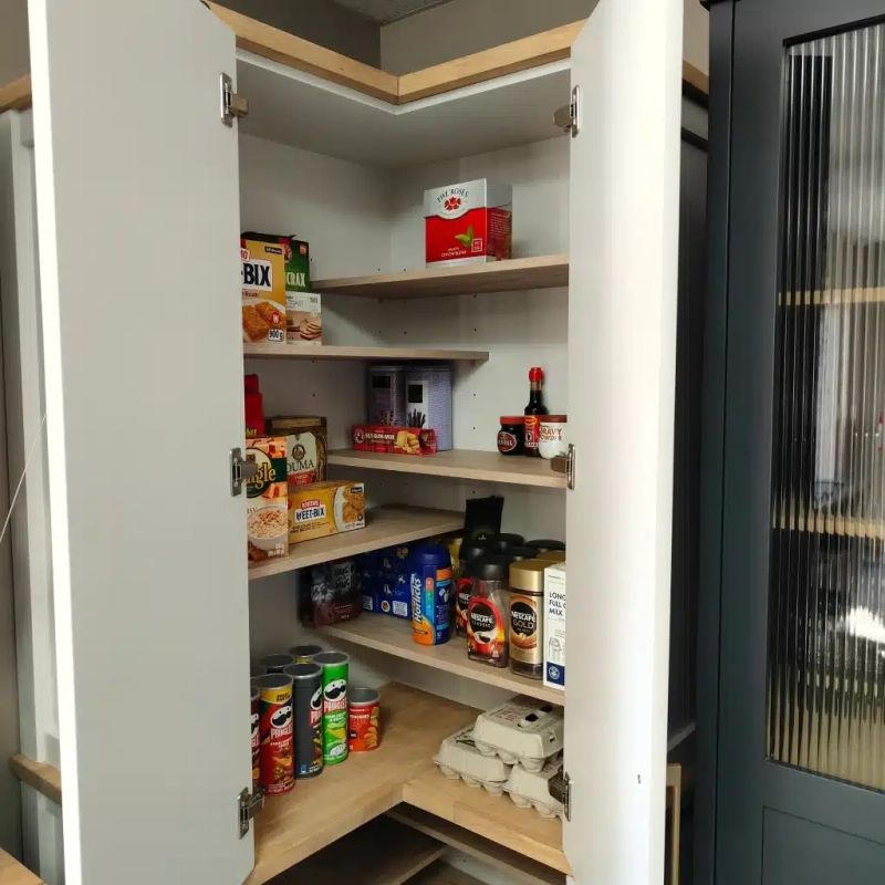 Split Corner Pantry White Open An open white split corner pantry with shelving and groceries inside